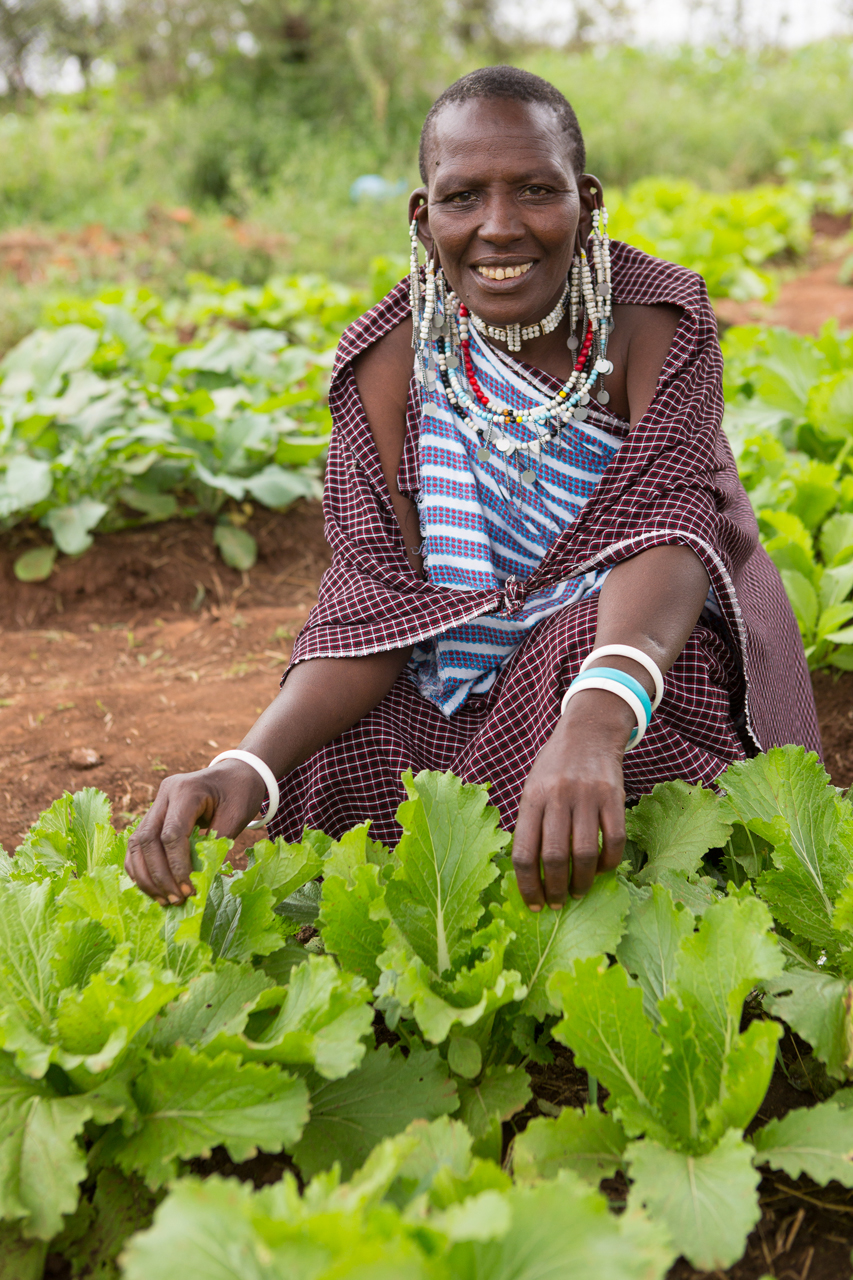 Photo of lady squatting over vegetable garden